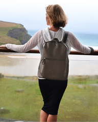 Woman looking out to sea wearing the Hartland gunmetal backpack on her back