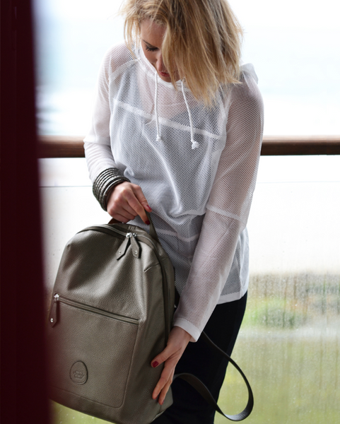 Woman holding the grey gunmetal Hartland backpack in her hand