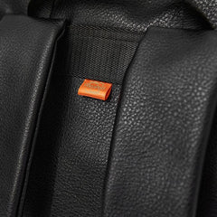 Detail image of the orange pacapod tag on the back of the backpack