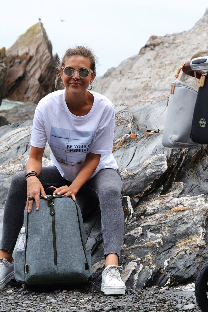Woman sitting on the rocks wearing sunglasses with a Picos Slate at her feet